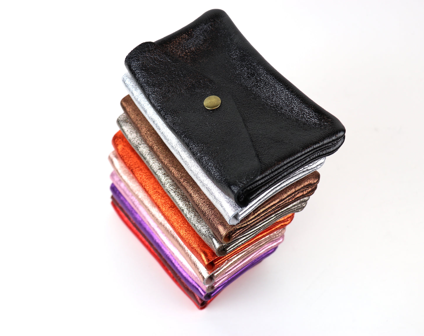 Top view of a stack of medium metallic pouches in multiple colors, emphasizing the different textures.