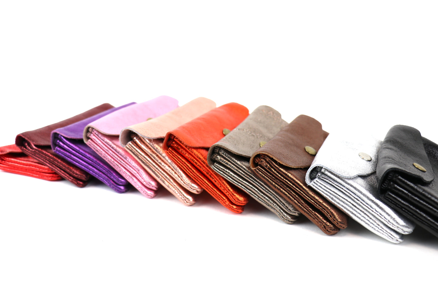 Side view of a stack of medium metallic pouches in different colors, showing their slim profiles and variety of shades.