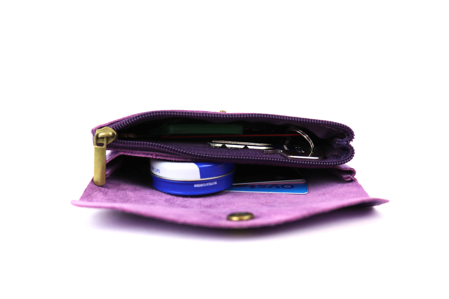 Side view of a purple metallic pouch, displaying its contents and the zipper compartment.