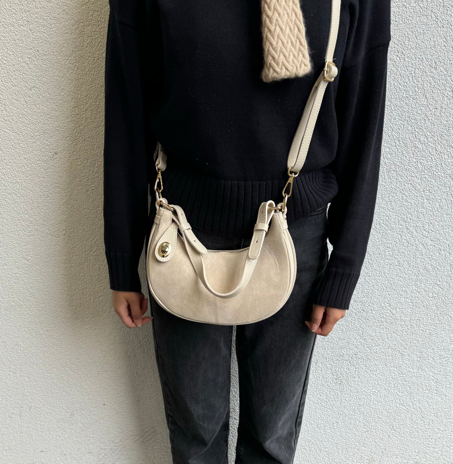 Cream half moon bag worn as a crossbody bag, front view.