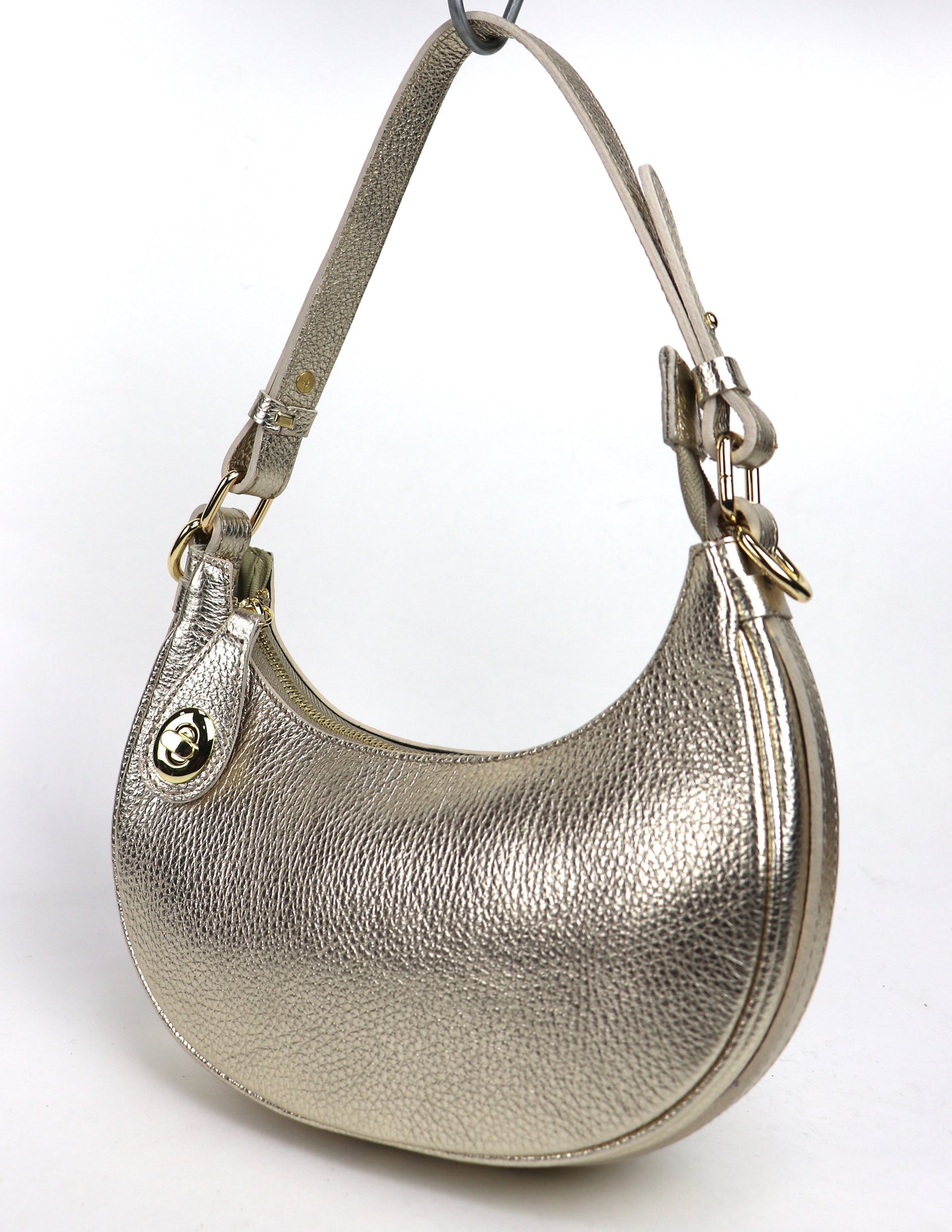 Gold small half moon shoulder/crossbody bag, angled side view, featuring metallic pebbled leather texture, gold-tone hardware, and adjustable strap displayed against a white background.