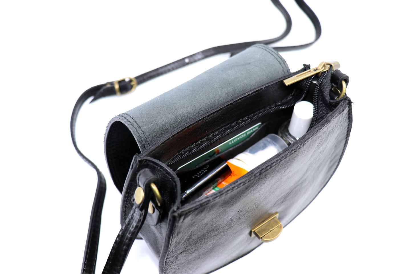 Open view of the black Cora Vintage Small Leather Crossbody Bag, displaying the beige interior lining and its content-holding capacity, on a white background.