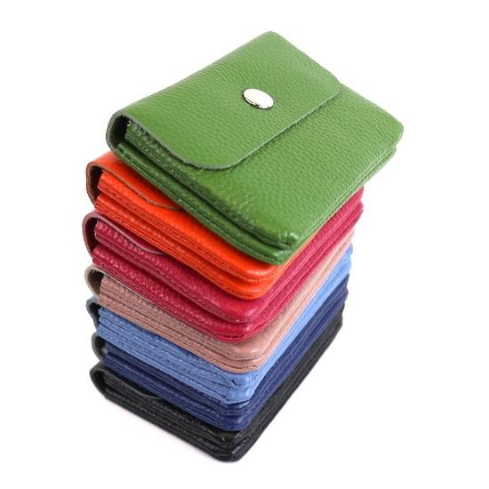A stack of leather wallets in various colors, arranged from top to bottom: olive green, bright orange, fuchsia, dusty pink, royal blue, denim blue, and black, each with a silver snap button