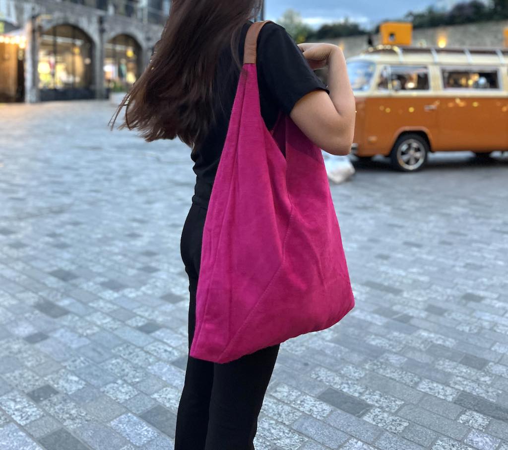 Model wearing the Fuchsia Pink Samantha Large Tote Laptop Bag while walking outdoors with a retro-style van in the background.