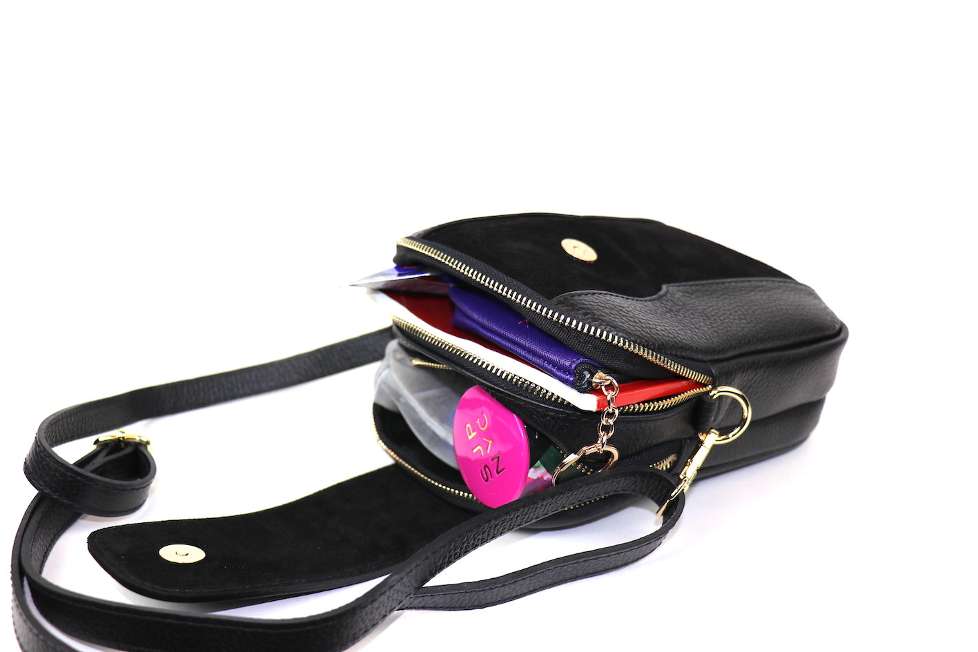 Open view of a Black Crossbody Bag with Detachable Straps, displaying interior compartments and personal items.
