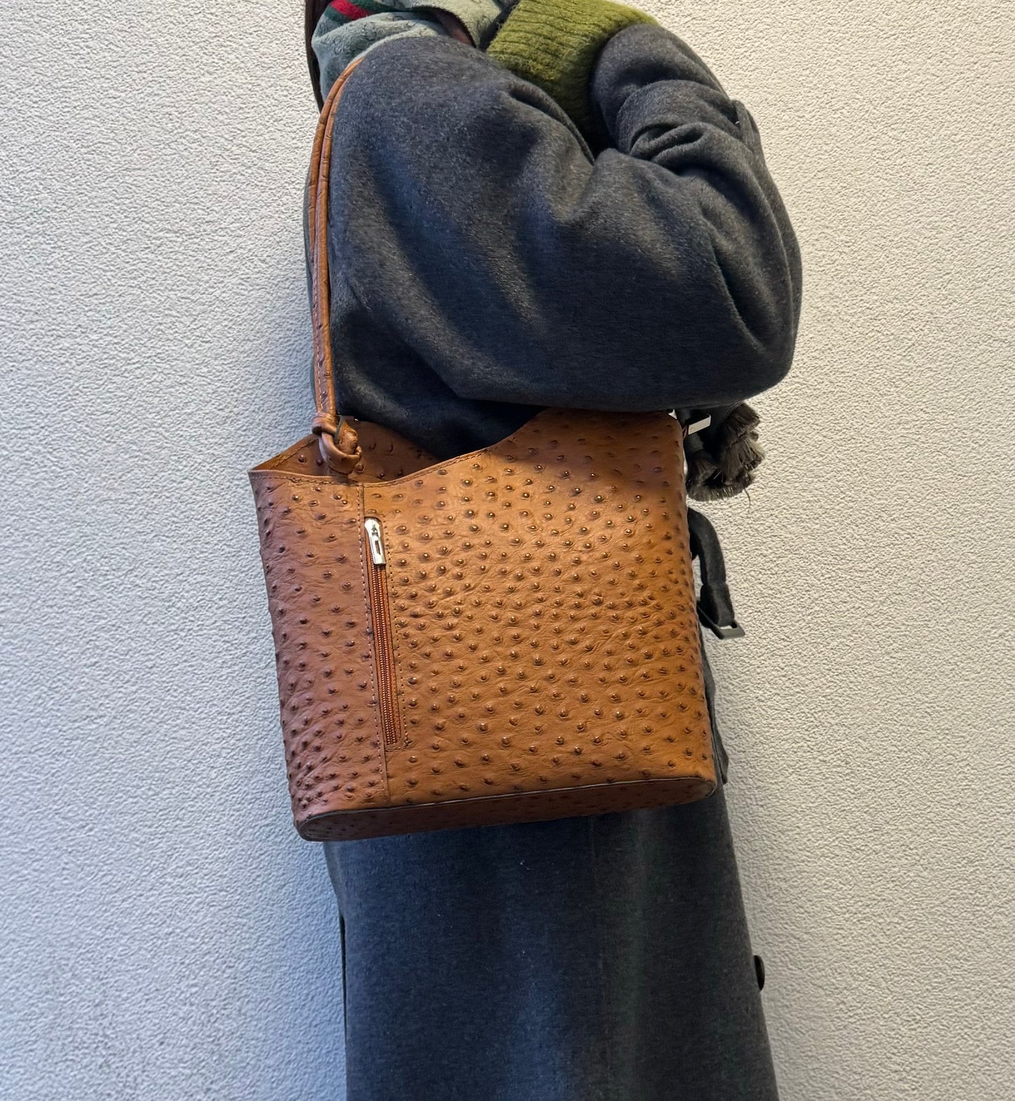 Woman wearing a Tan Single-Tone Ostrich Style Italian Leather Convertible Backpack, angled back view displaying the backpack style.
