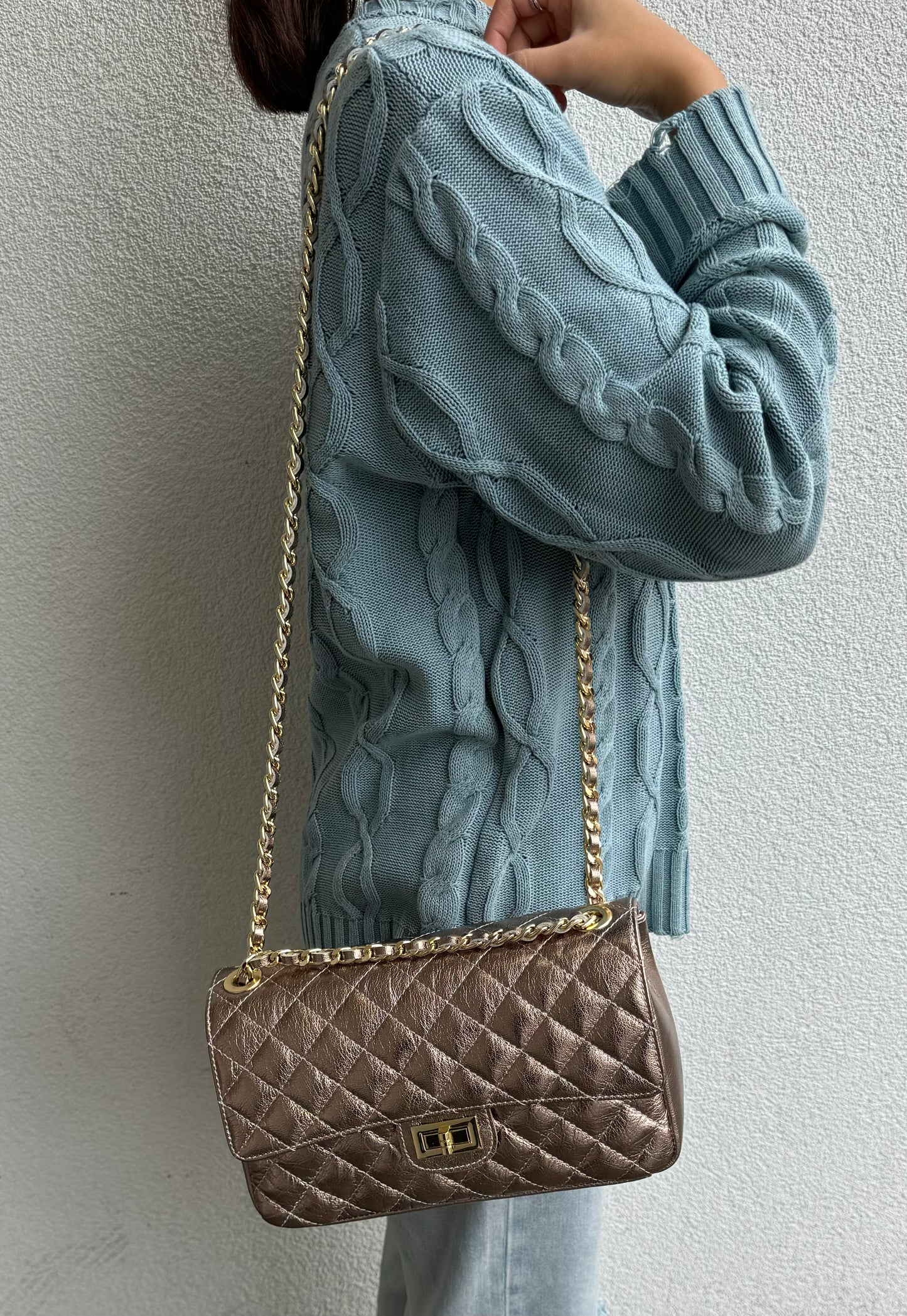 A metallic bronze quilted bag with a gold chain strap, offering a luxurious look.