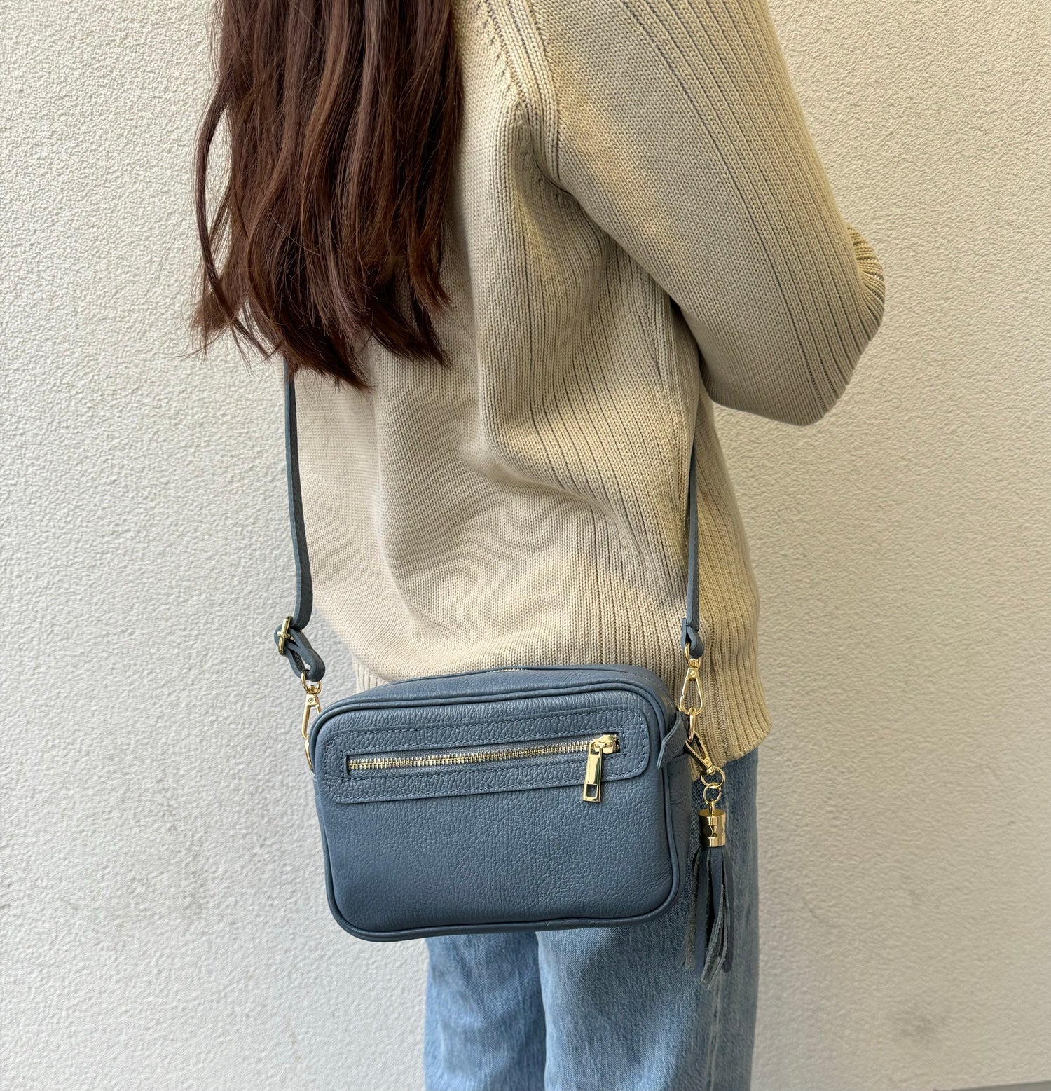 A girl wearing denim blue leather box bag with gold hardware