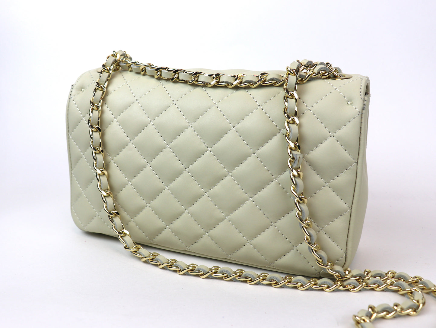 Back view of a cream-colored quilted leather bag with a gold chain strap, displayed against a plain background.






