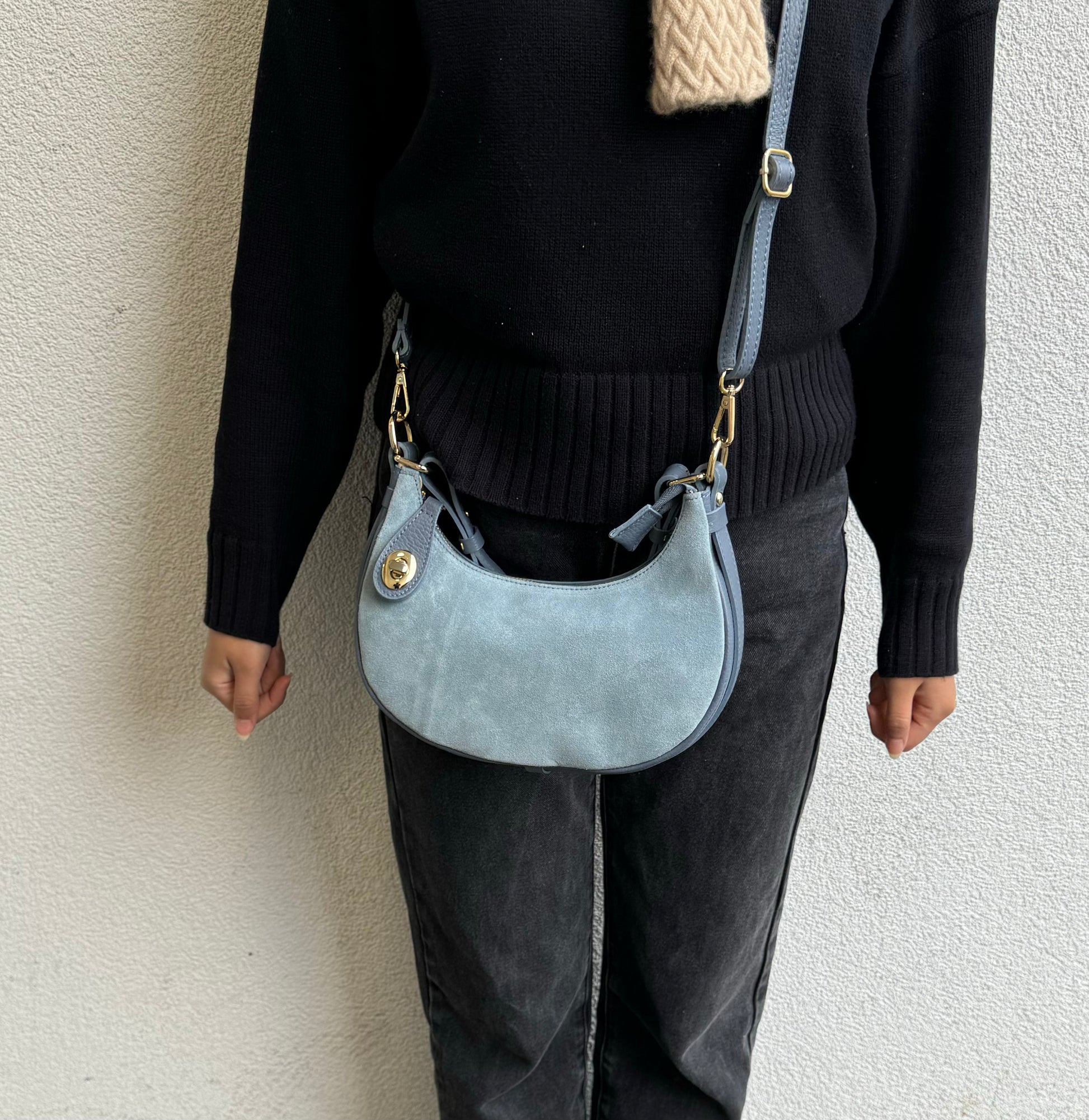 Person wearing Denim Blue half moon bag as a crossbody.
