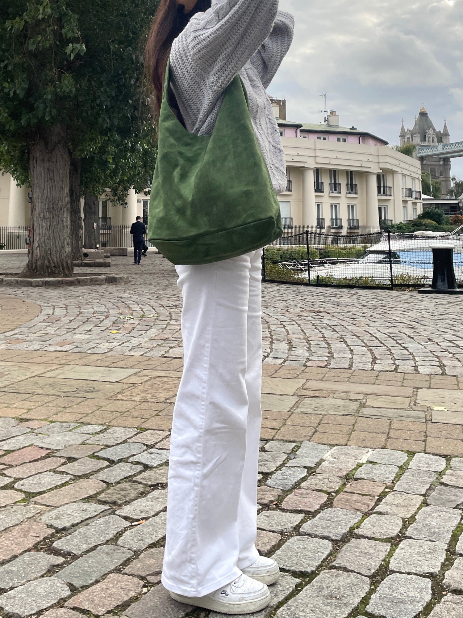 A girl wearing olive green suede hobo shoulder bag