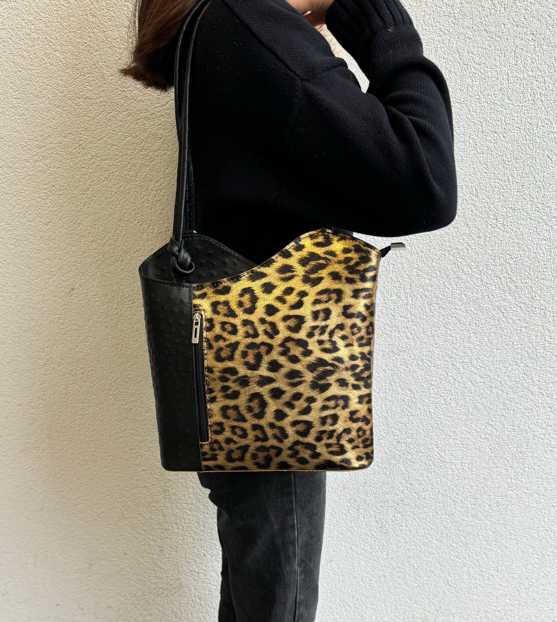 Person wearing Gold Leopard leather bag as a shoulder bag.