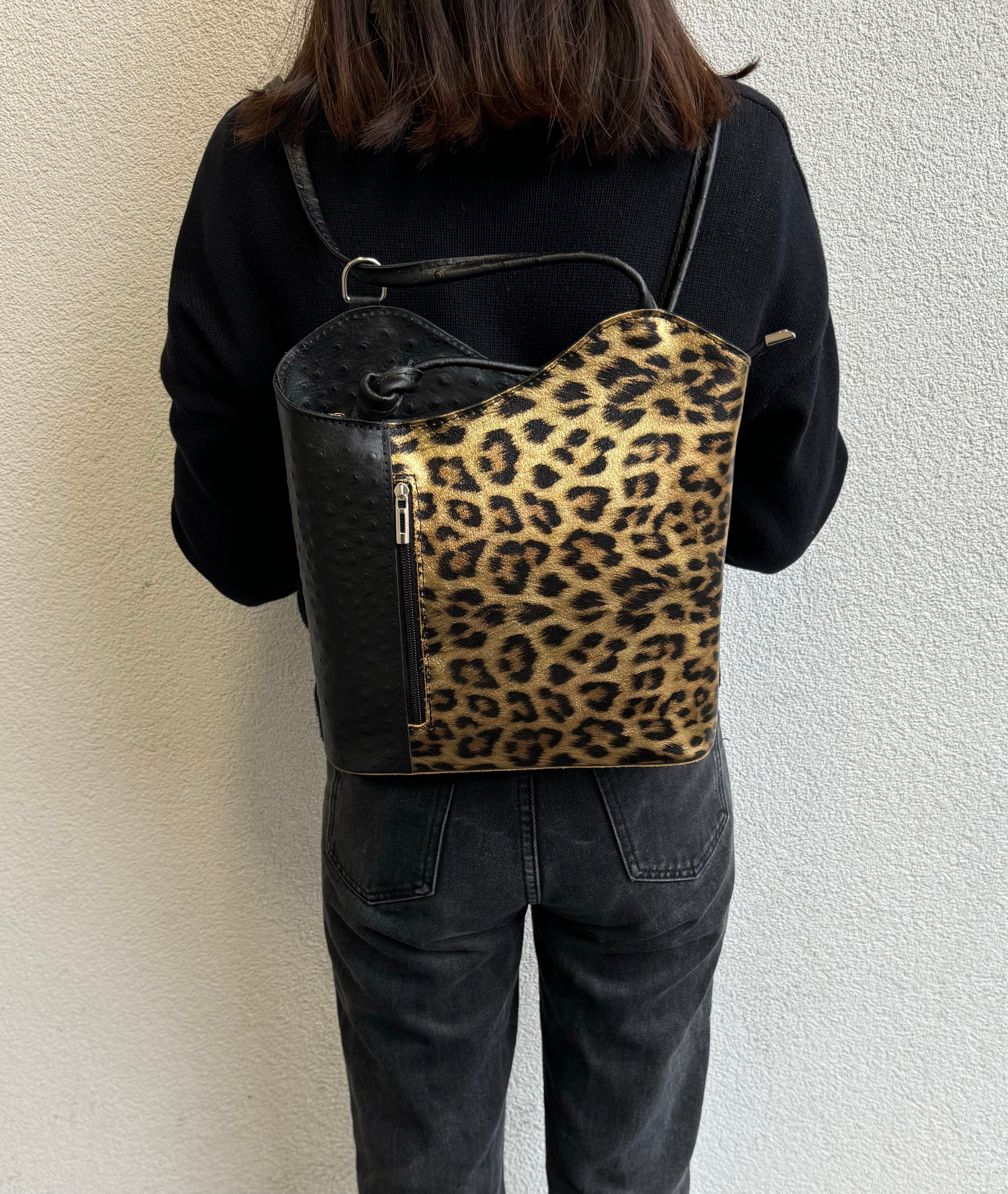 Person wearing Gold Leopard leather bag as a backpack.
