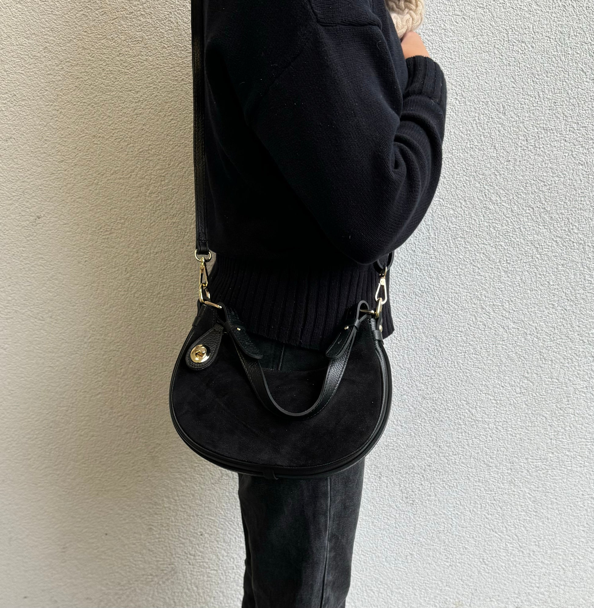 Person wearing Black half moon bag as a crossbody bag.