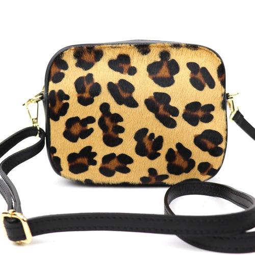 Leopard print fur bag with detachable black strap and gold hardware, displayed front-facing.