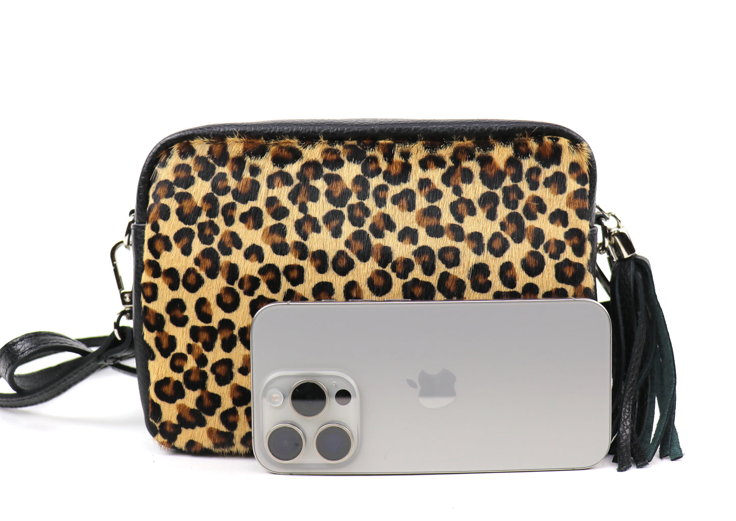 Leopard print leather bag next to a smartphone, highlighting the size of the bag.