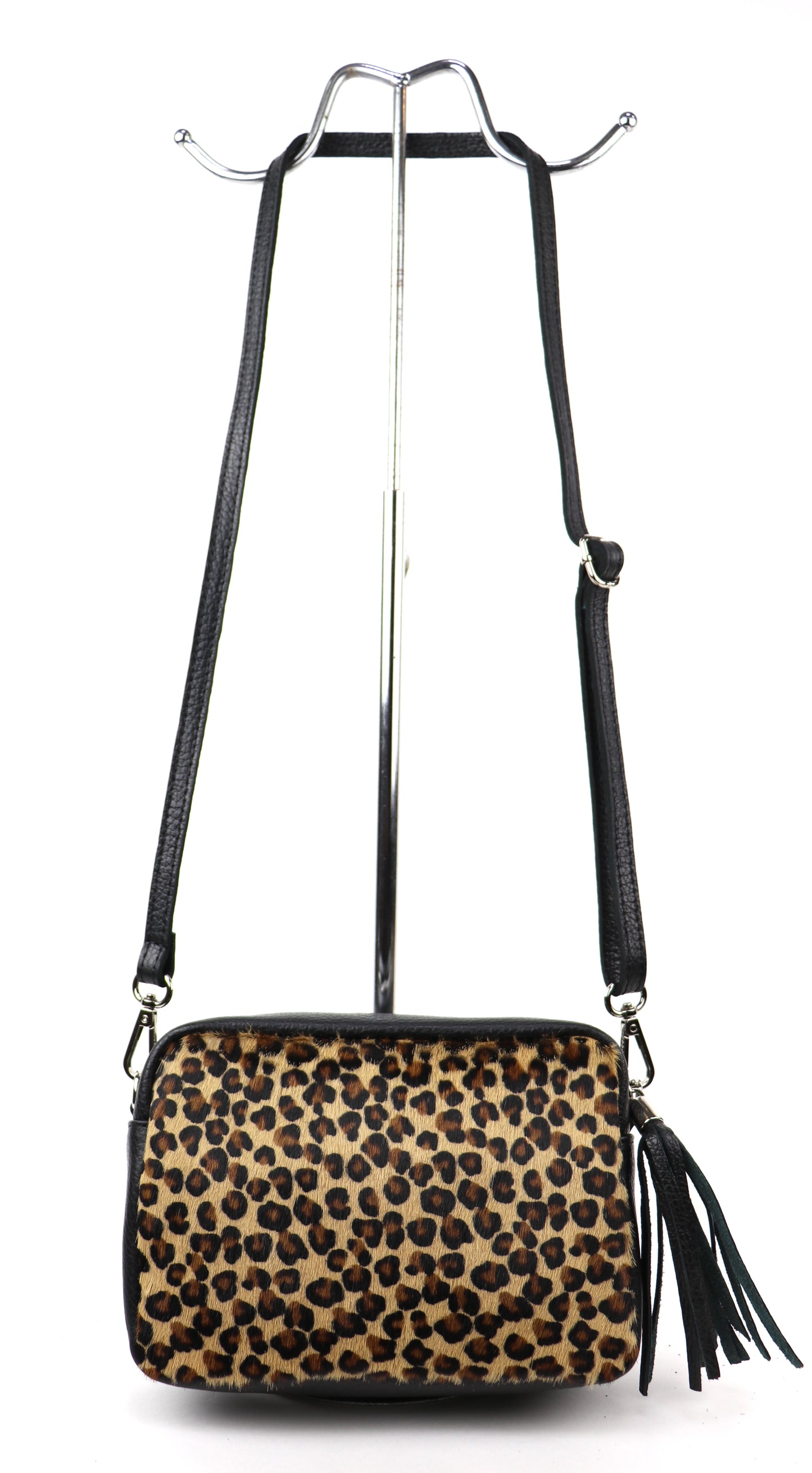 Leopard print leather bag with a long strap, displayed hanging against a white background.