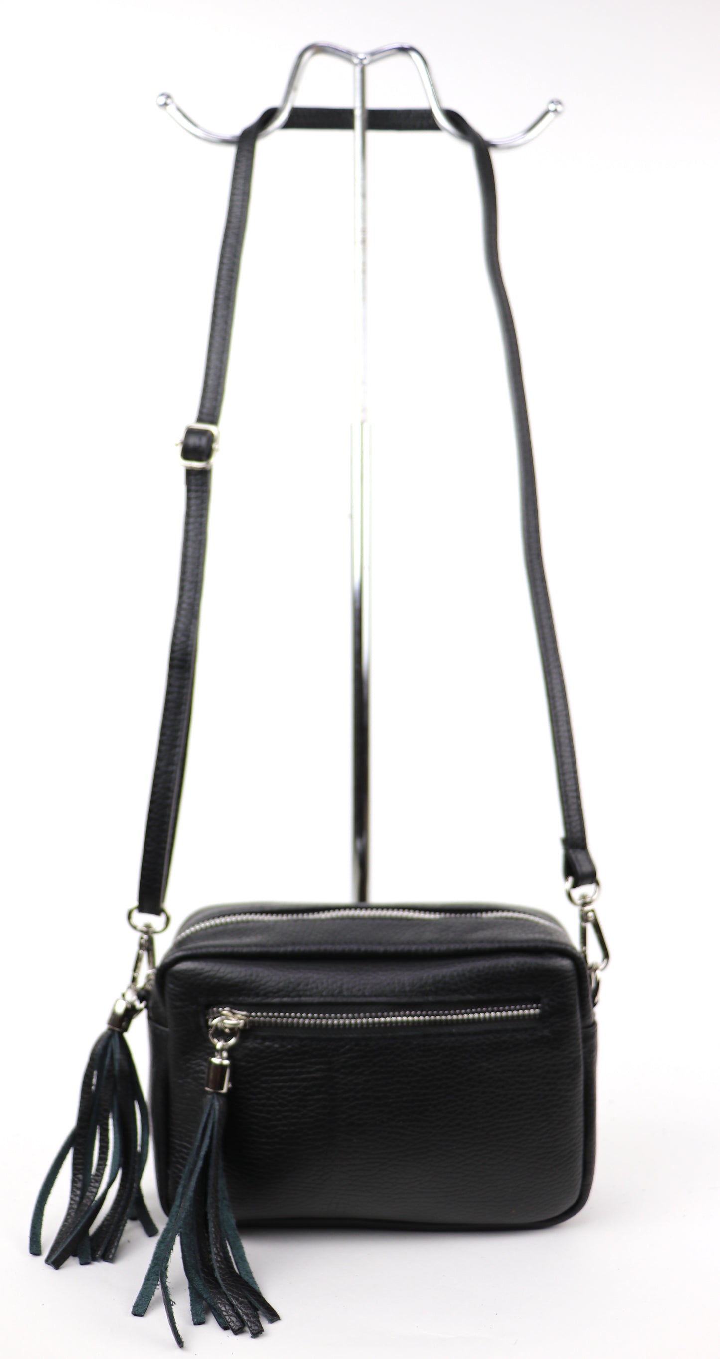 Pony print leather bag with a long strap, displayed hanging against a white background.