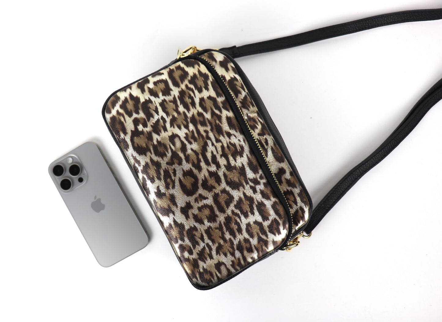 Top view of the Gold Leopard print leather bag, showing the open zipper and interior with a smartphone placed inside.