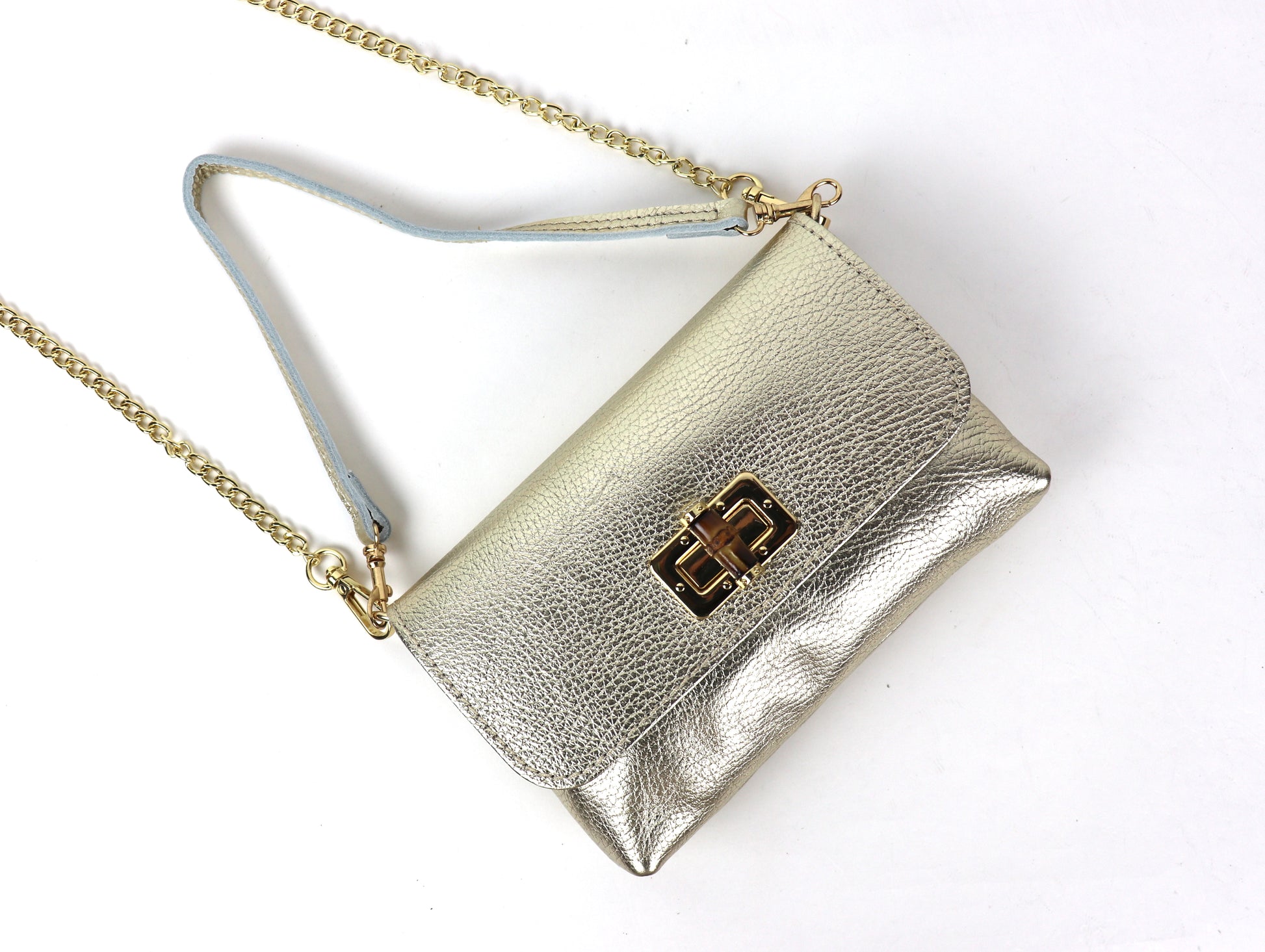 Angled view of a gold metallic leather bag, showcasing its shiny material and design.
