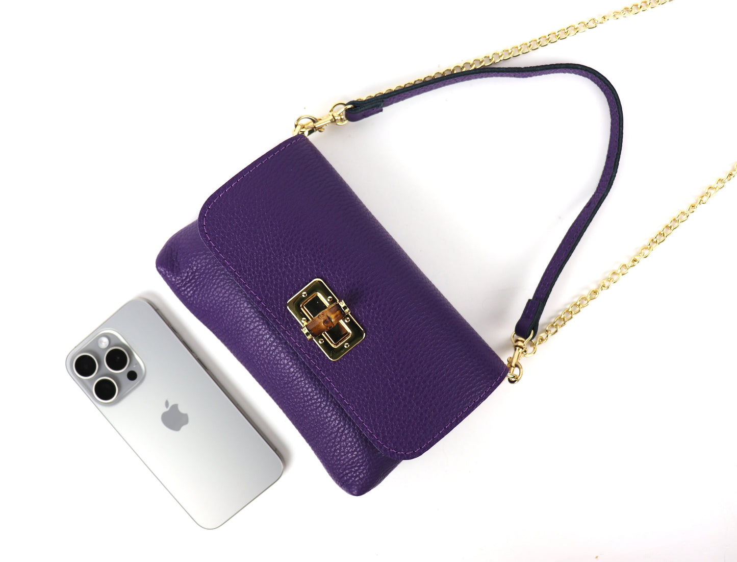 Purple leather bag next to a smartphone, demonstrating the bag’s size.