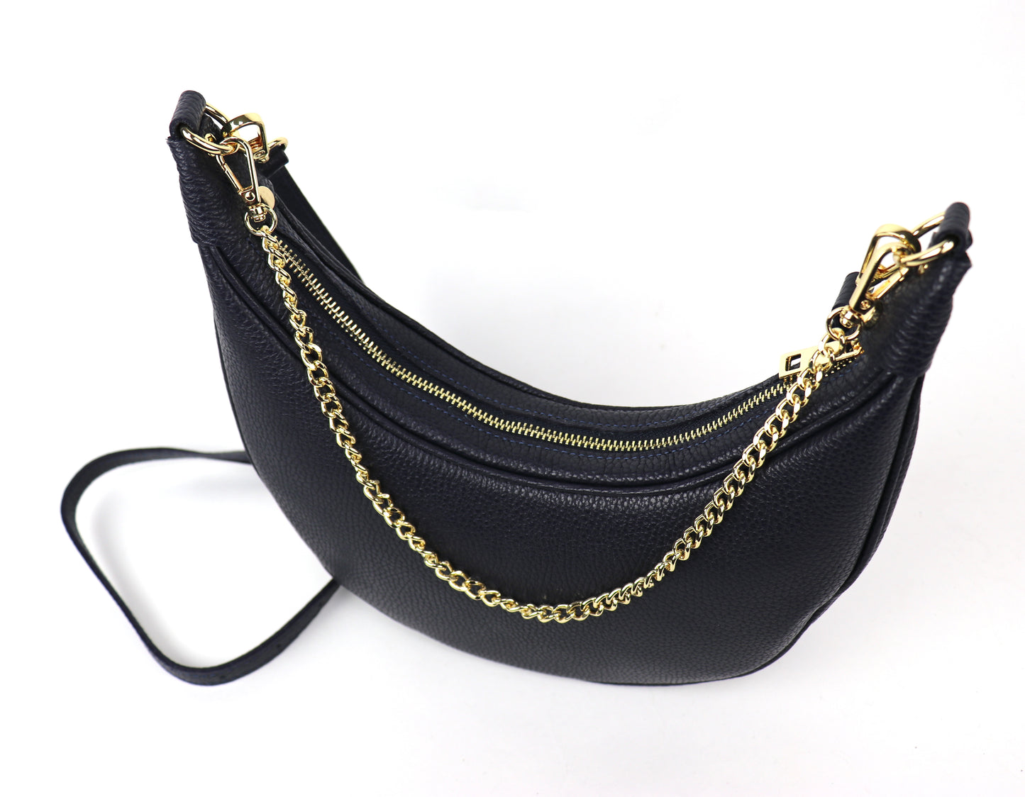 Top View: A navy crescent-shaped leather crossbody bag with a gold chain strap, photographed from a top angle. The zipper is closed, and the bag’s pebbled texture is visible, emphasizing the elegant design and shiny gold hardware.