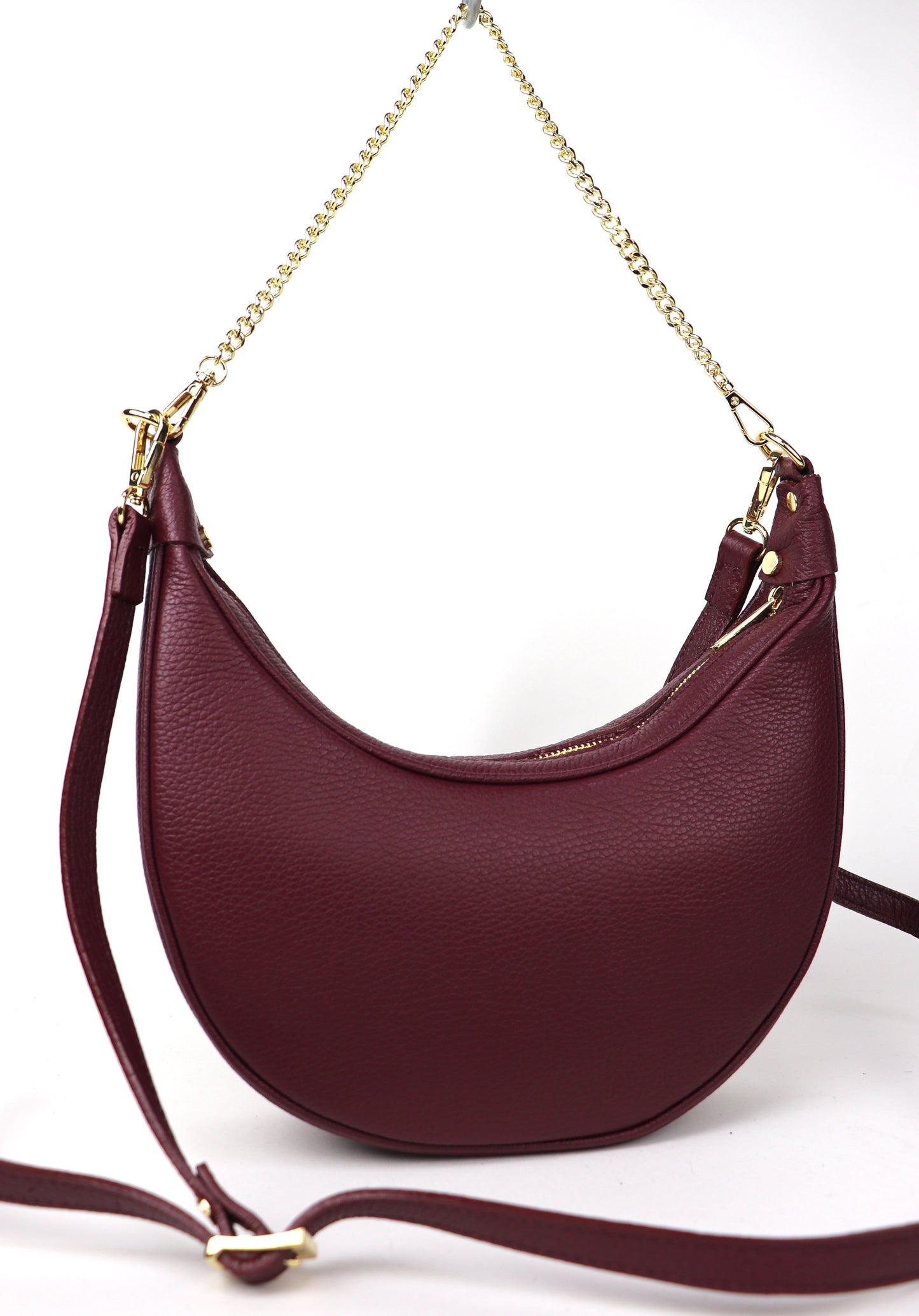 A burgundy leather crossbody bag with gold chain detailing, shown from the front against a white background.