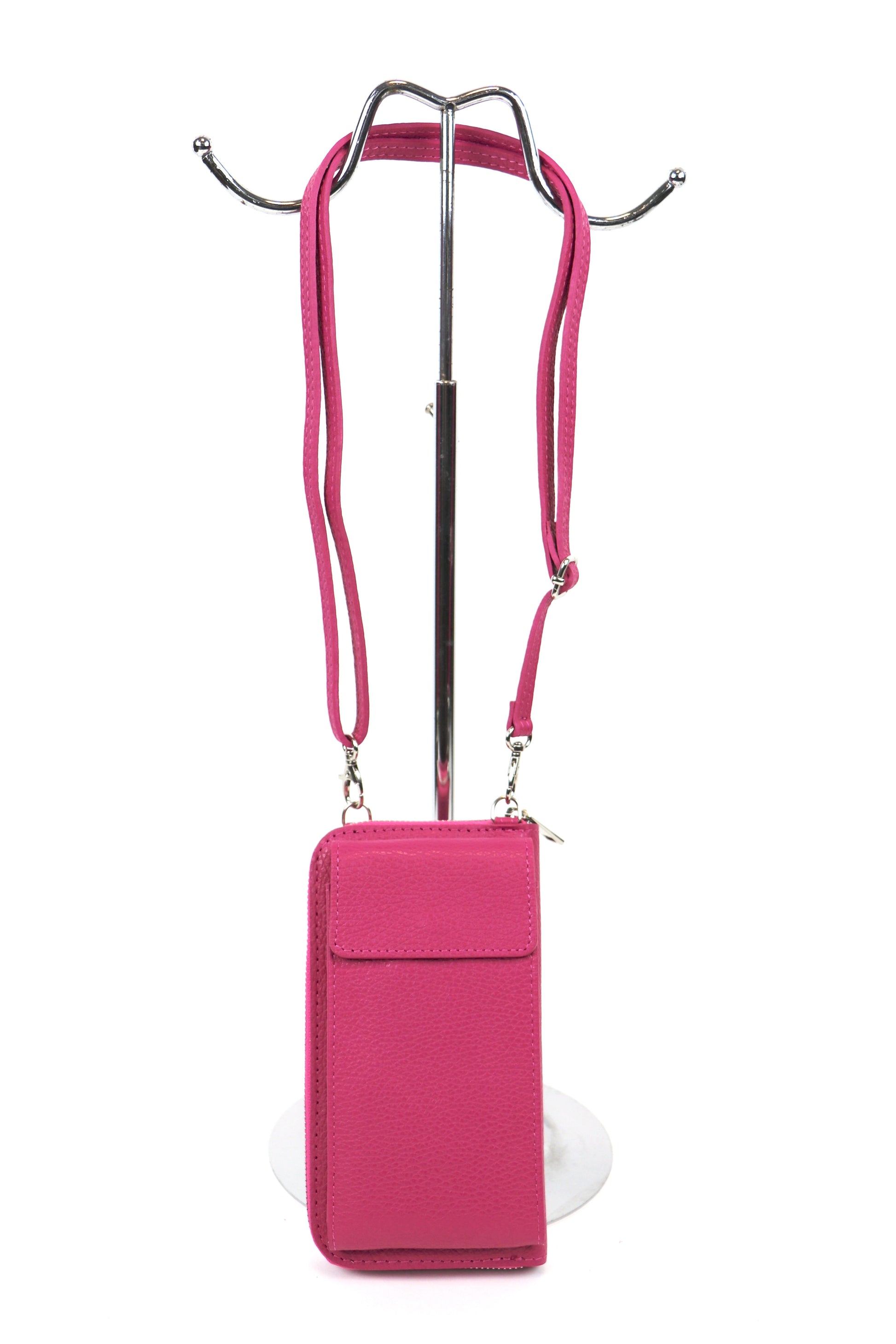 Pink crossbody bag with an adjustable strap hanging on a metal stand.









