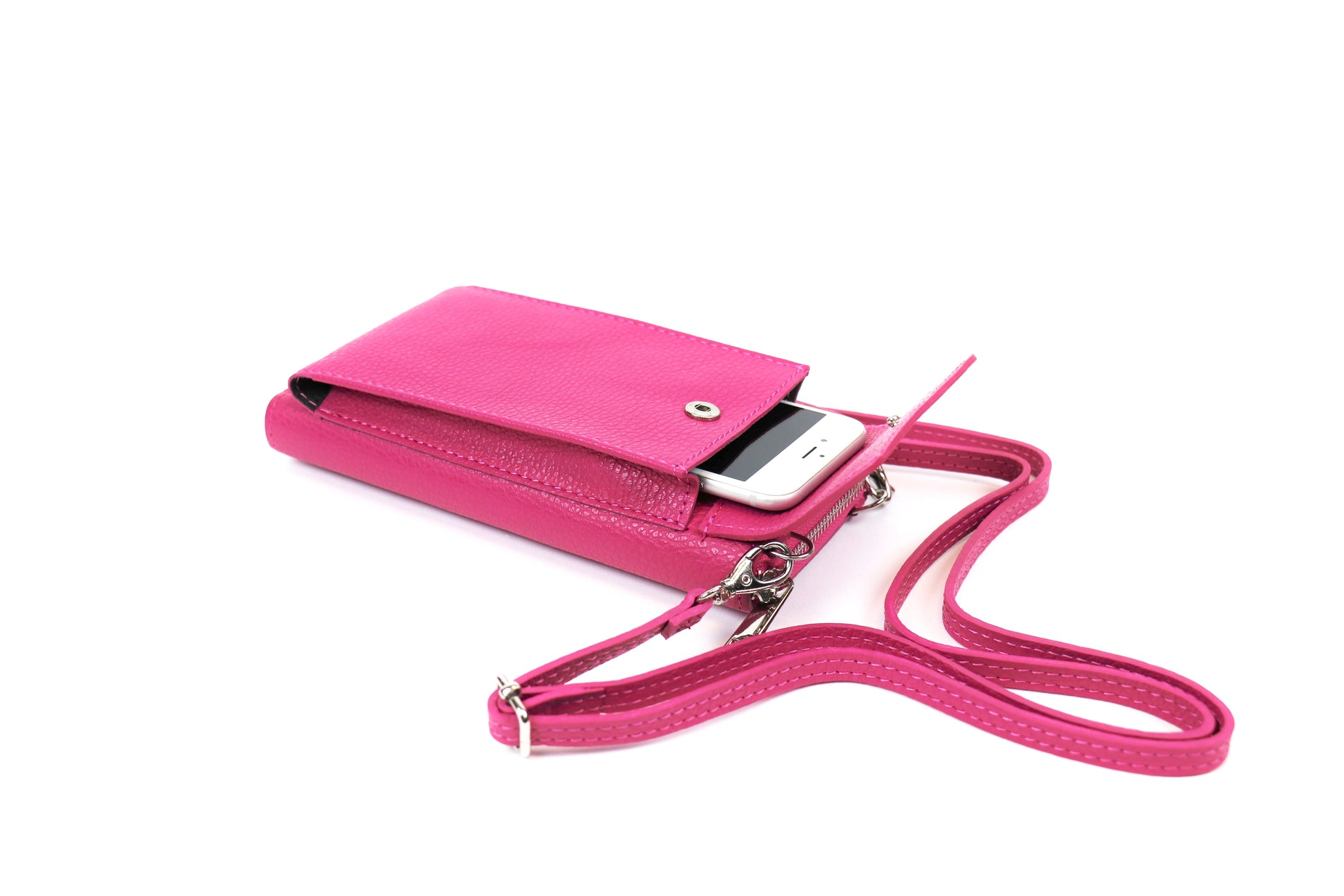 Pink crossbody bag with a phone partially inserted into the front flap pocket and an attached pink strap.