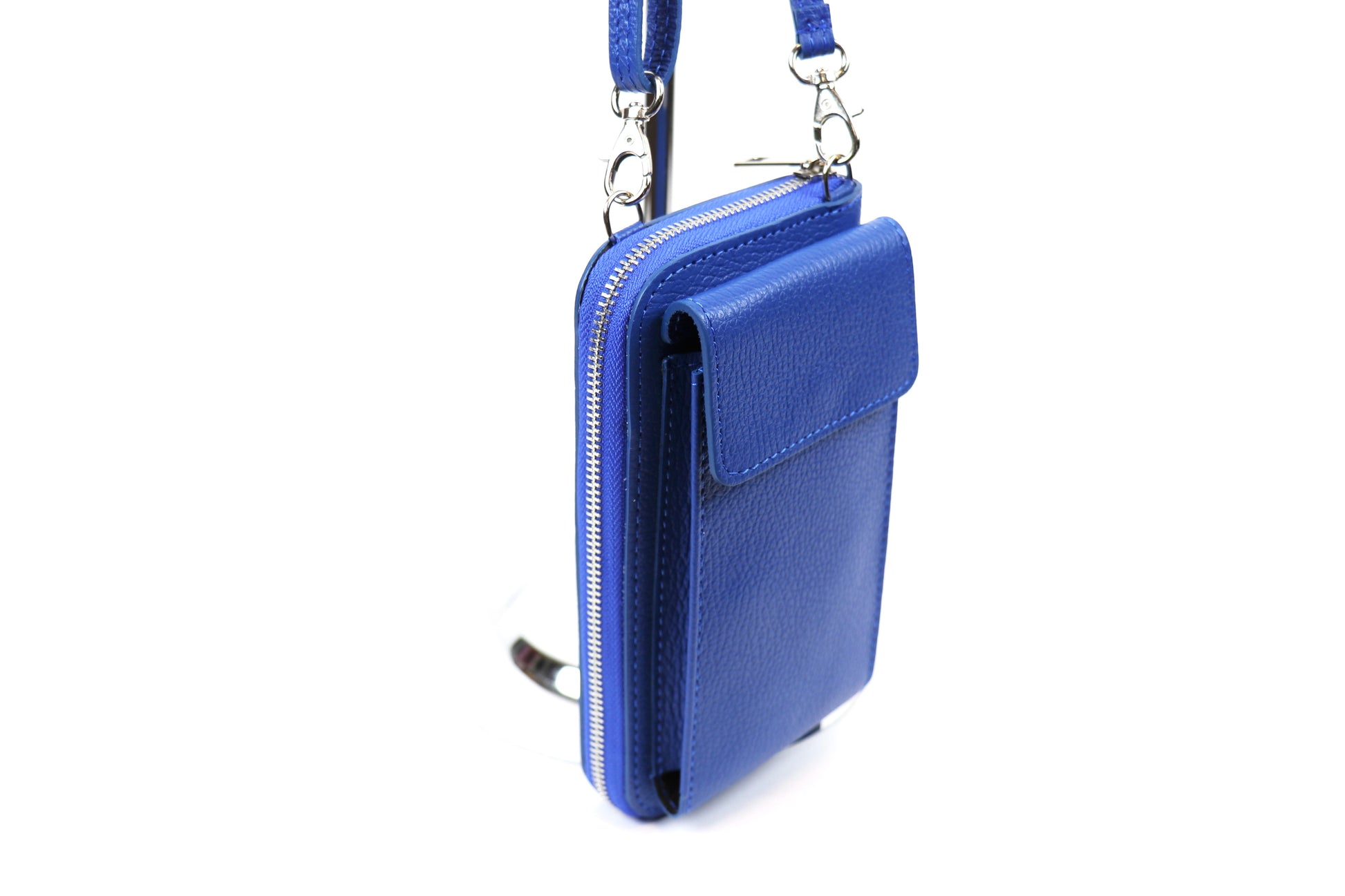 Side view of the royal blue Vera Leather Crossbody Bag hanging from a stand.