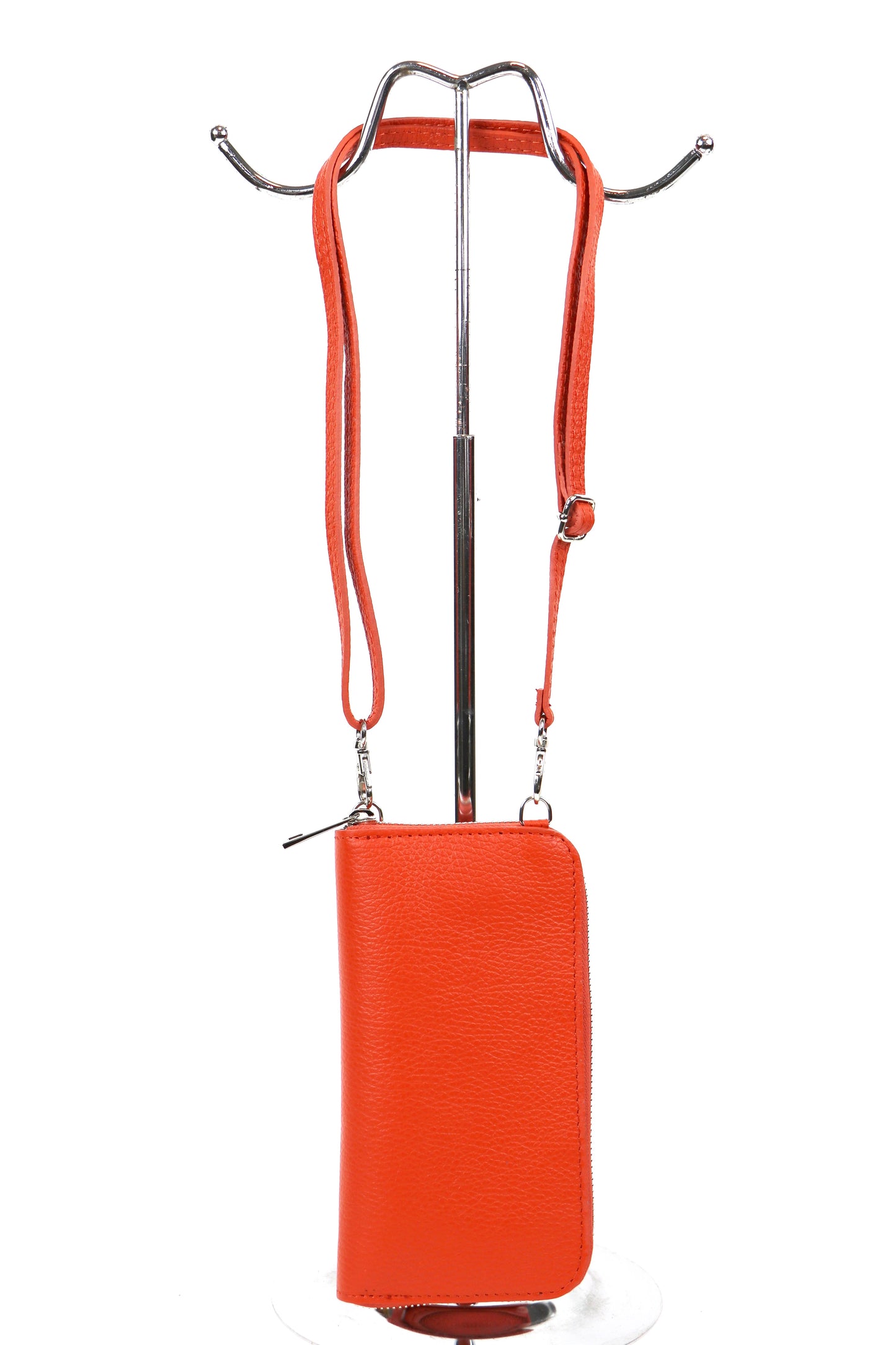 Orange crossbody bag with an adjustable strap hanging on a metal stand.