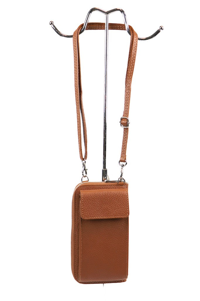 Brown leather crossbody bag with adjustable strap hanging on a metal stand.