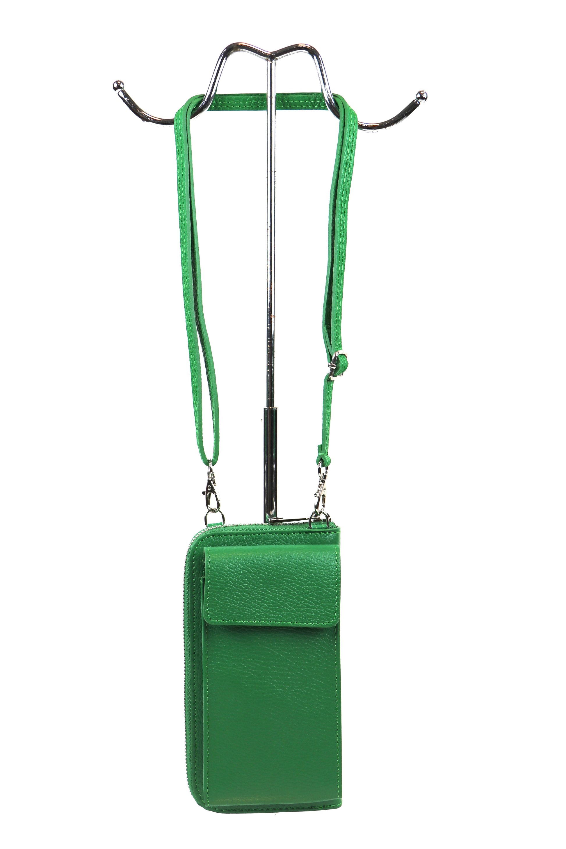 Green crossbody bag with a front flap pocket and adjustable strap, hanging on a metal stand.






