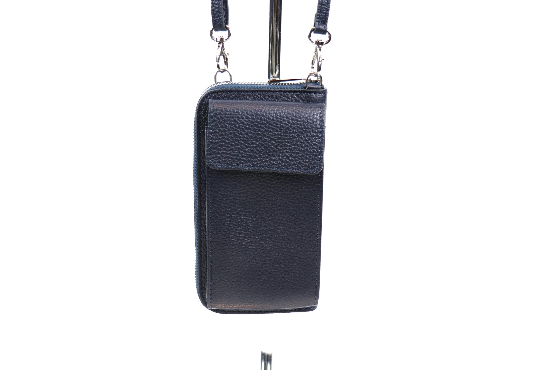 Front view of a navy blue crossbody bag hanging from a stand.