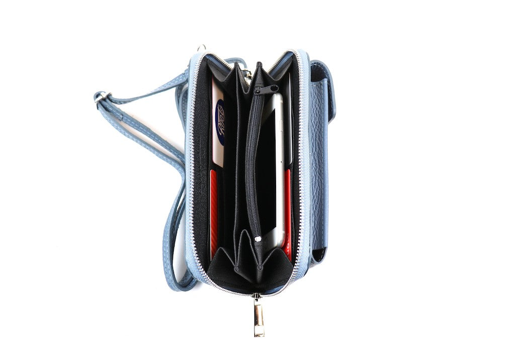 Open Blue crossbody bag showing cards and a phone stored in its compartments.






