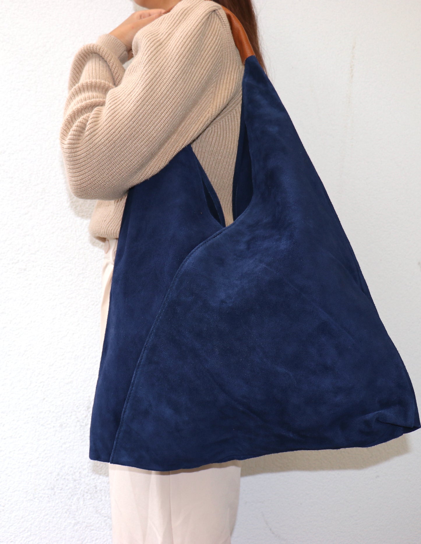 Side view of the Denim Blue Samantha Tote held by a model.