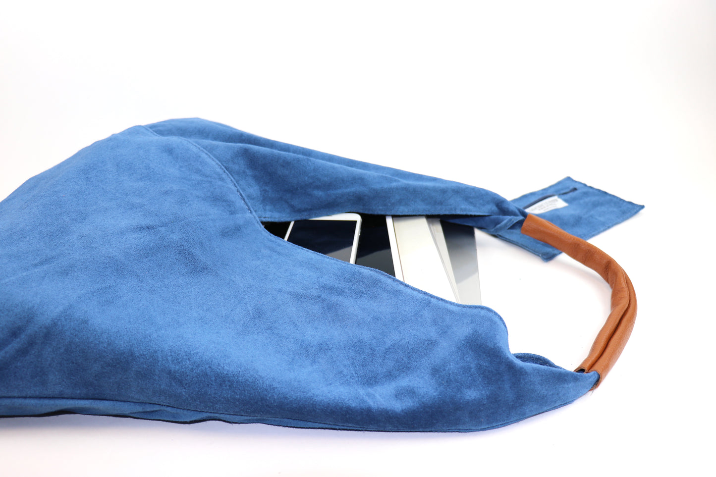 Close-up of the Denim Blue Samantha Large Tote Laptop Bag showing a tablet inside and brown leather handles on a white background.