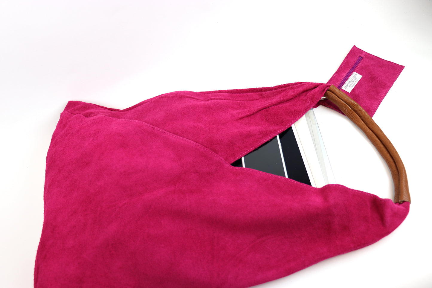 Close-up of the Fuchsia Pink Samantha Large Tote Laptop Bag showing a tablet inside and brown leather handles on a white background.