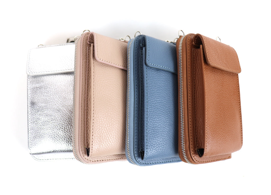 Four leather wallets in silver, beige, blue, and brown, standing upright with flap closures visible.