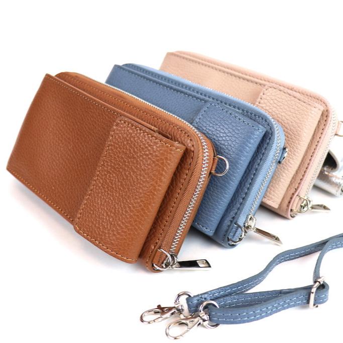 Three textured leather wallets in brown, blue, and beige with wrist straps and silver hardware.