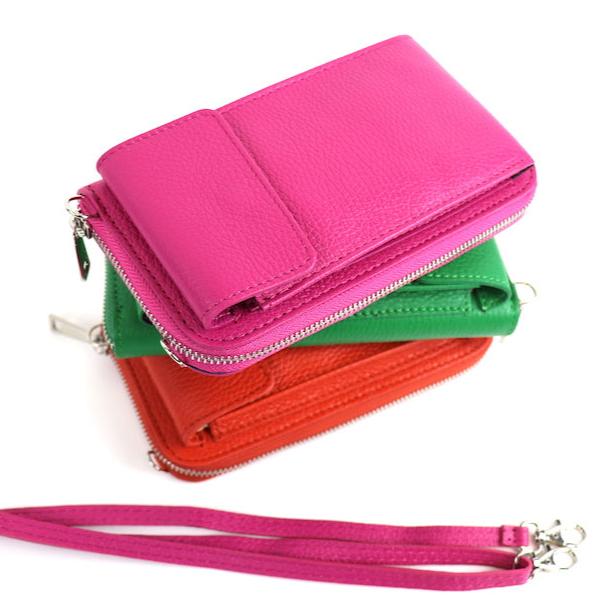 Stack of crossbody bags in pink, green, and orange with a detachable pink strap placed beside them.