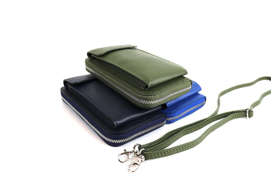 Stacked Olive Green, Navy Blue, and Royal Blue Crossbody Bags: Three Vera Leather Crossbody Bags in olive green, navy blue, and royal blue stacked on top of each other, with straps shown.