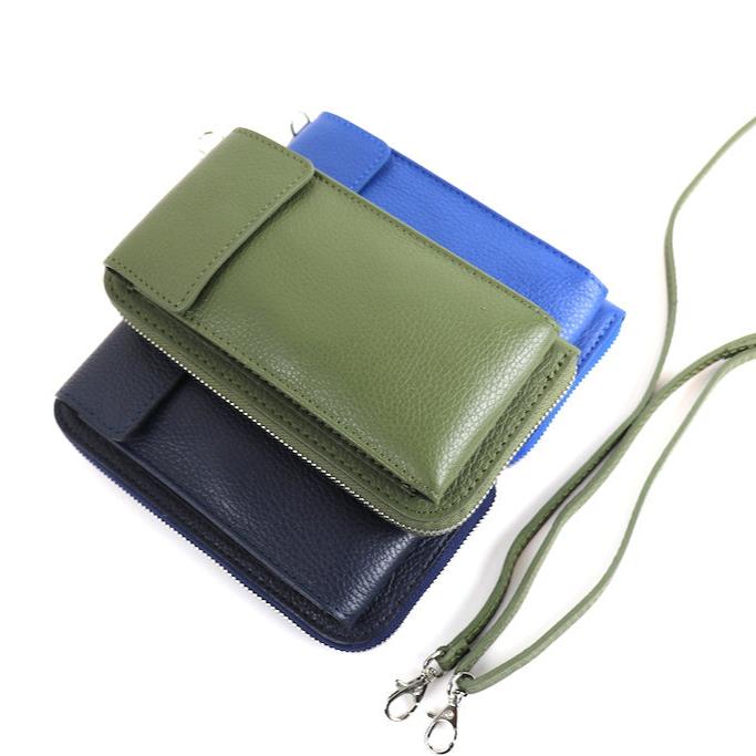 Three Vera Leather Crossbody Bags in olive green, navy blue, and royal blue stacked on top of each other, with straps shown.