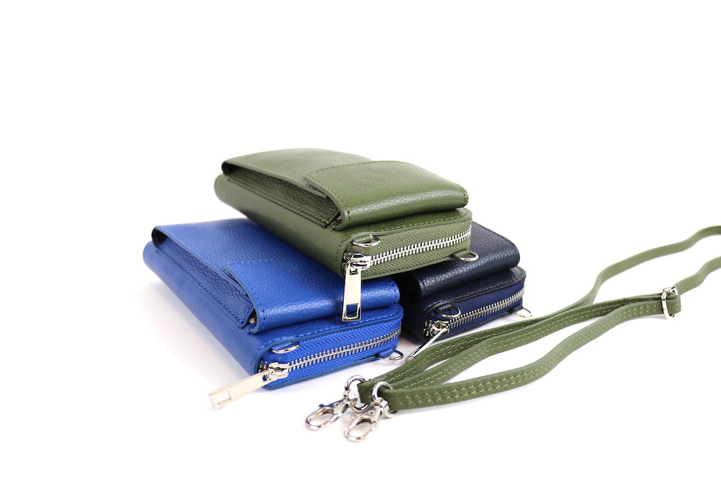 Three Vera Leather Crossbody Bags in olive green, navy blue, and royal blue stacked on top of each other, with straps shown.