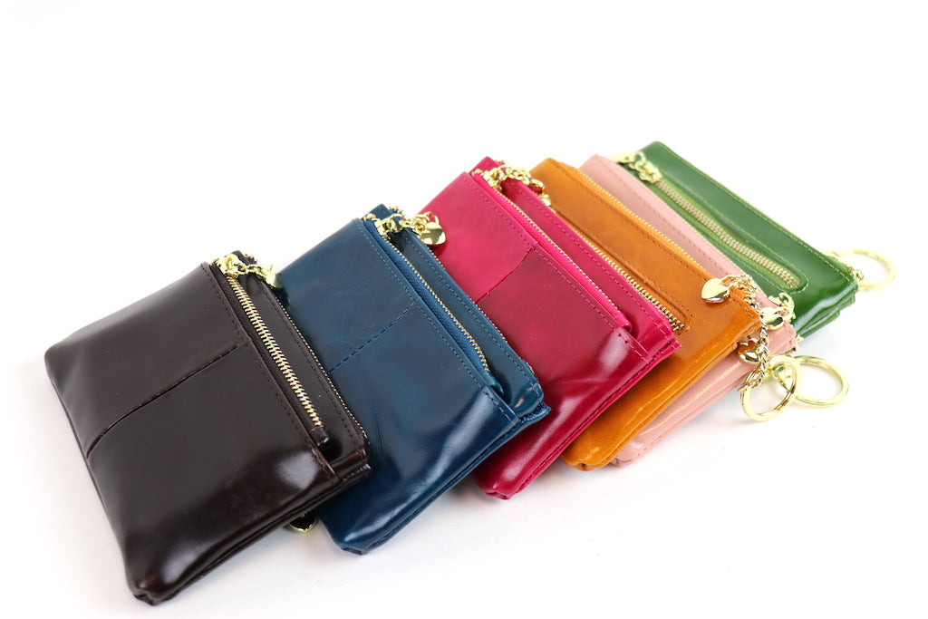 Group of leather pouches in various colors (black, navy, fuchsia, dusty pink, green, light tan).